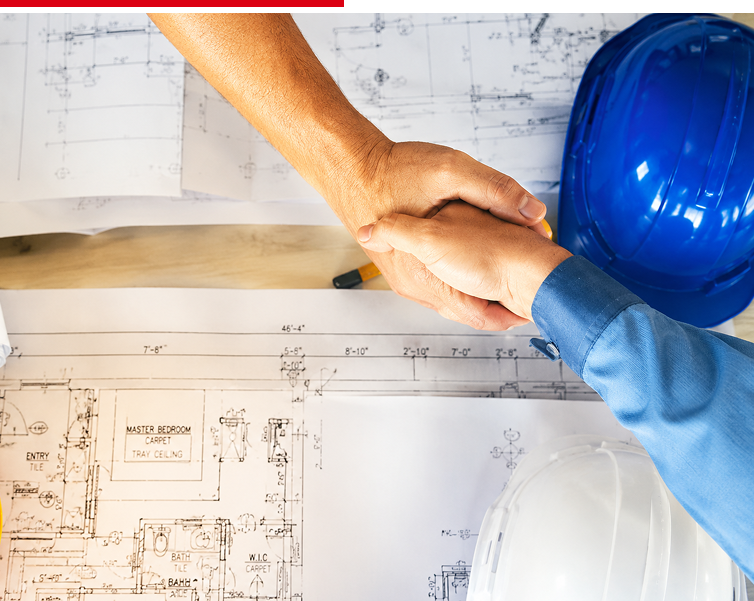 Handshake over blueprints with hard hats